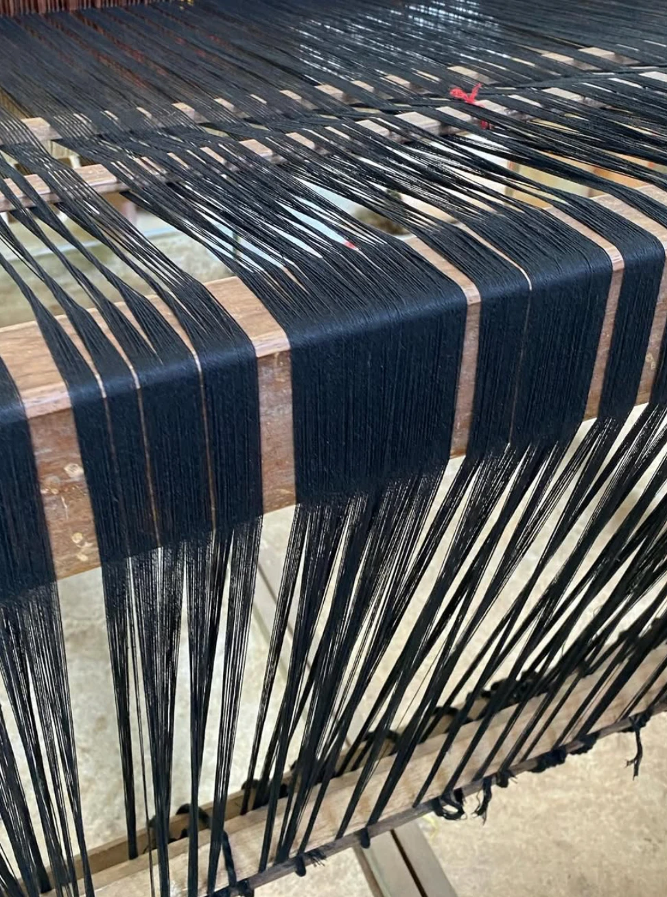 Black warp threads set up on a traditional handloom